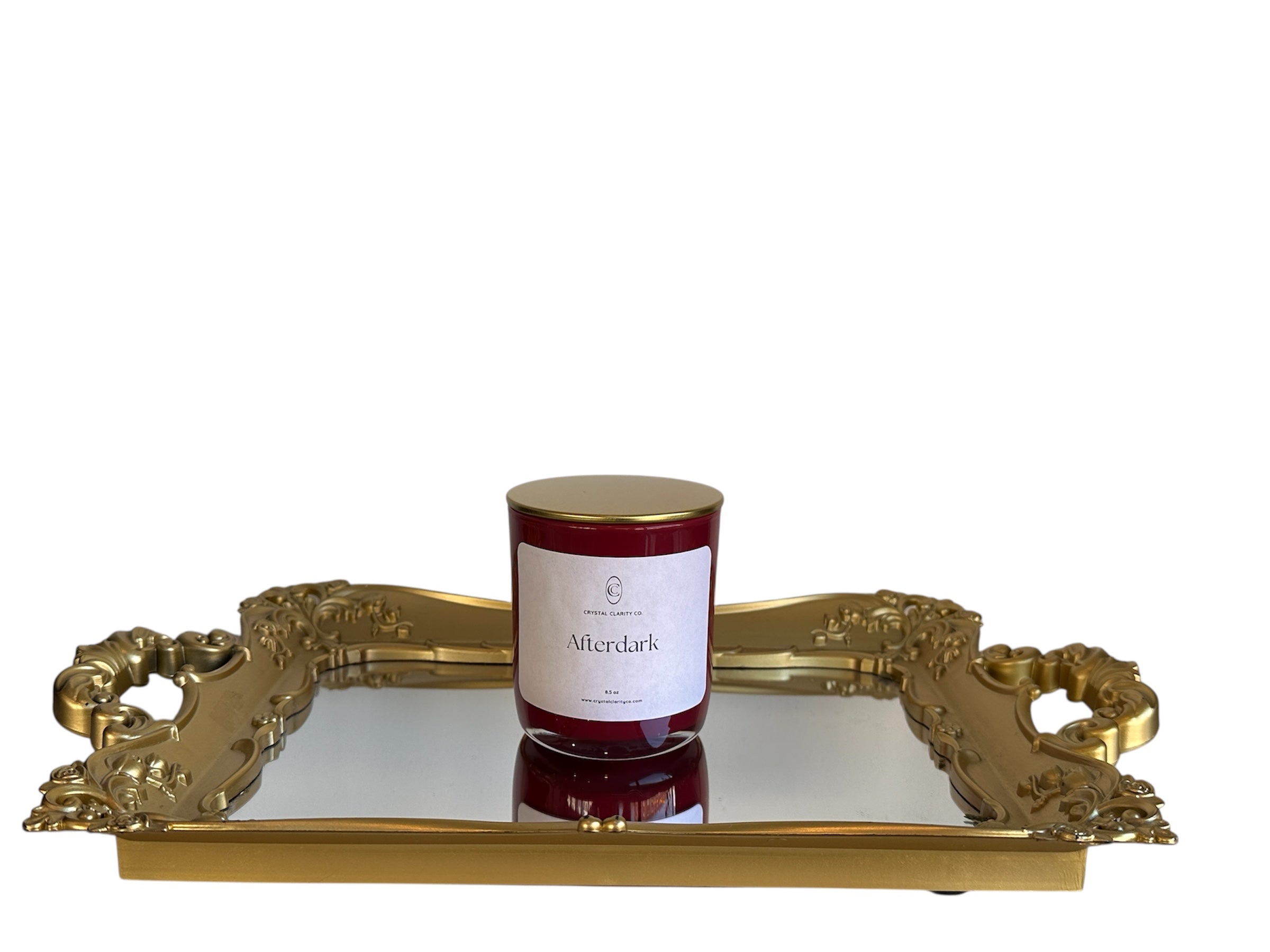 Candle labeled 'Afterdark' on a decorative gold tray with a white background